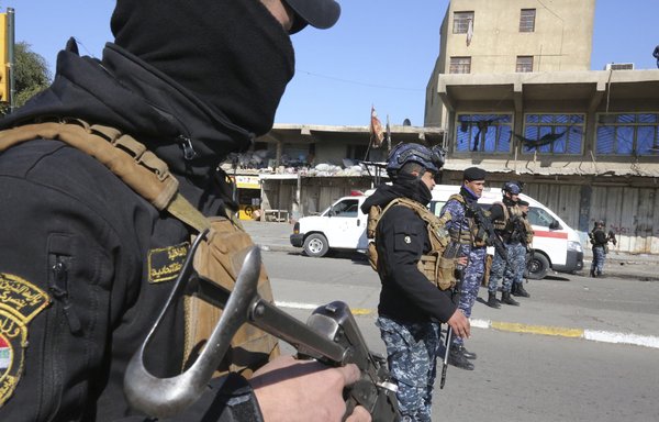Iraqi forces stand guard following a twin suicide bombing in Baghdad on January 21 that was later claimed by ISIS. More than 30 people were killed in the attack. [Sabah Arar/AFP]