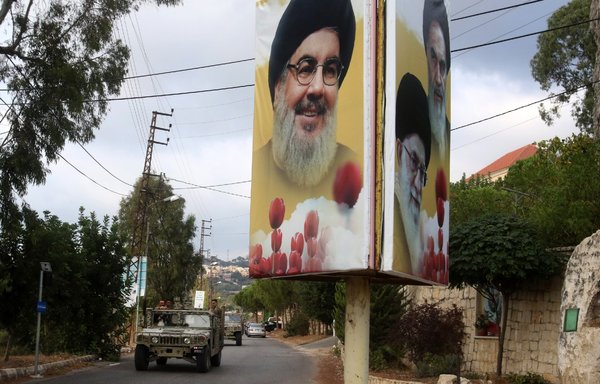 A Lebanese army convoy in Ain Qana last September passes by a billboard that bears pictures of Hassan Nasrallah, Ali Khamenei and Ayatollah Khomeini. [Mahmoud ZAYYAT / AFP]
