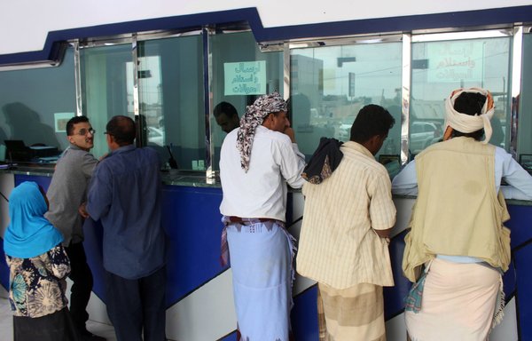 Yemenis queue at a money exchange office in Aden on January 23, 2020. [Saleh al-Obeidi/AFP]