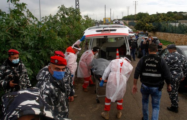 Lebanese forces gather as medics on February 4 remove the body of activist and intellectual Lokman Slim from the spot near Sidon where he was found dead. [Mahmoud Zayyat/AFP]