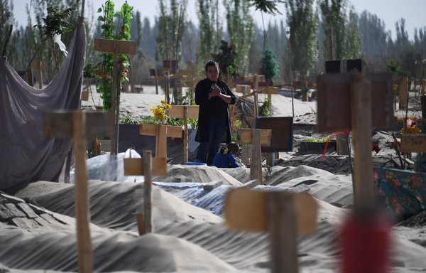 امرأة تزور مقبرة للأيغور عند أطراف هوتان بمنطقة شينجيانغ في الصين بتاريخ 31 أيار/مايو 2019. [غريغ بيكر/وكالة الصحافة الفرنسية]