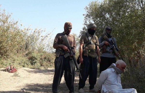 A picture posted by ISIS in October shows three members about to execute an old man. Since the collapse of the so-called 'caliphate', the surviving members of the group have resorted to mobster style tactics in order to continue funding their activities. [File]