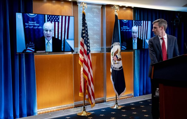 US special envoy for Yemen Timothy Lenderking appears on a pair of screens during a news teleconference at the State Department in Washington on February 16, as State Department spokesman Ned Price stands at the podium. [Andrew Harnik/POOL/AFP]