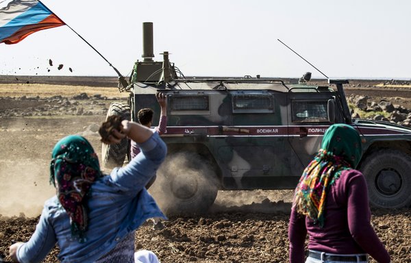 Syrians throw rocks at a Russian military convoy near the village of Ein Diwar in al-Hasakeh province, Syria, on October 11 in an attempt to stop the convoy from reaching its destination. [Delil Souleiman/AFP]
