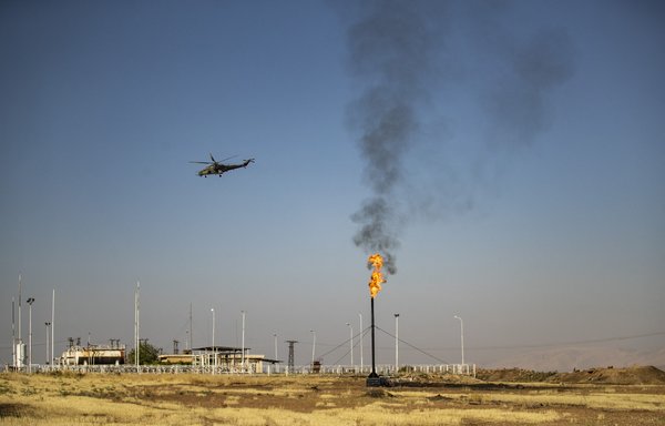 A Russian army helicopter, part of a patrol, flies over an oil field in al-Qahtaniyah, al-Hasakeh province, Syria, October 11. [Delil Souleiman/AFP]