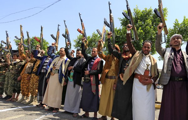 Yemeni gunmen loyal to the Iran-backed Houthis brandish their weapons during a rally in Sanaa last July 7. [Mohammed Huwais/AFP]