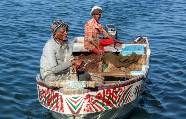 Yemeni fishermen sit in their boat in the Red Sea waters off the port city of al-Hodeidah on January 1, 2019. [AFP]
