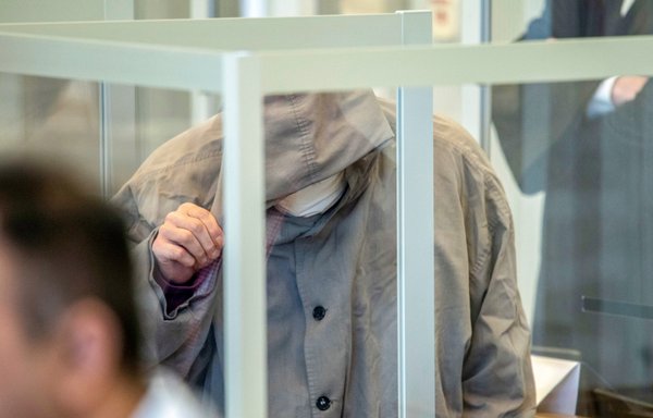 In this file photo taken last April 23, Syrian defendant Eyad al-Gharib hides his face as he arrives for an unprecedented trial on state-sponsored torture in Syria, at court in Koblenz, western Germany. [Thomas Lohnes/AFP/POOL]