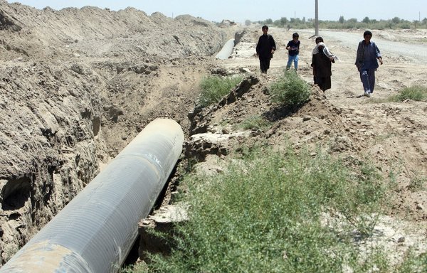إيرانيون يمرون في آب/أغسطس 2007 قرب خط أنابيب في زاهدان بمحافظة سيستان وبلوشستان، وهي إحدى أفقر المناطق في البلاد. [صورة وكالة الصحافة الفرنسية/ستر/إسنا]