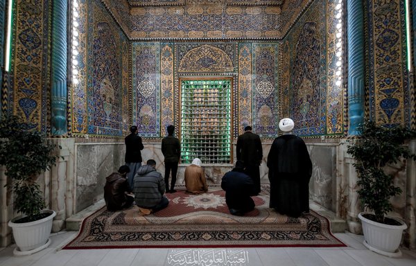 Iraqis pray at Imam Ali shrine in Najaf on December 6. [Imam Ali Holy Shrine/Facebook]