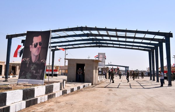 Pro-regime forces gather at the border-crossing between Albu Kamal in Syria and al-Qaim in Iraq, taken from the Syrian side, in Deir Ezzor province, on September 30, 2019. Iran-backed militias regularly use this crossing to transfer weapons and materiel across the border. [AFP]