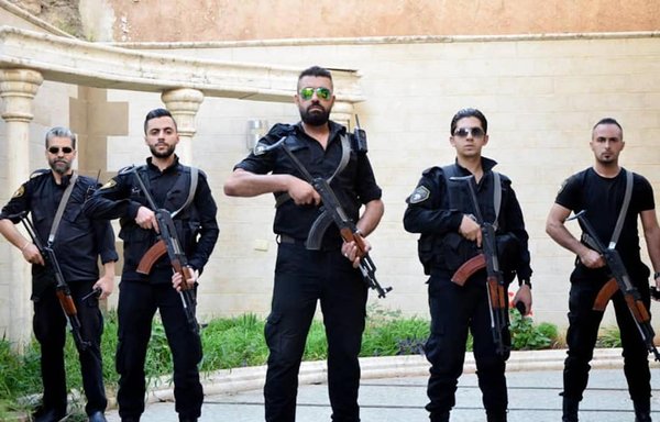 عناصر من شركة شروق الأمنية المملوكة من ماهر الأسد، شقيق الرئيس السوري، يستعدون لالتقاط صورة لهم مع أسلحتهم. [شركة شروق للحماية والحراسات/فيسبوك]