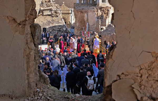 Pope Francis addresses people from the podium at the square near the ruins of the Syriac Catholic Church of the Immaculate Conception, in the old city of Mosul on March 7. Pope Francis, on his historic Iraq tour, visited Christian communities that endured the brutality of ISIS until the group was defeated in 2017. [Zaid al-Obeidi/AFP]