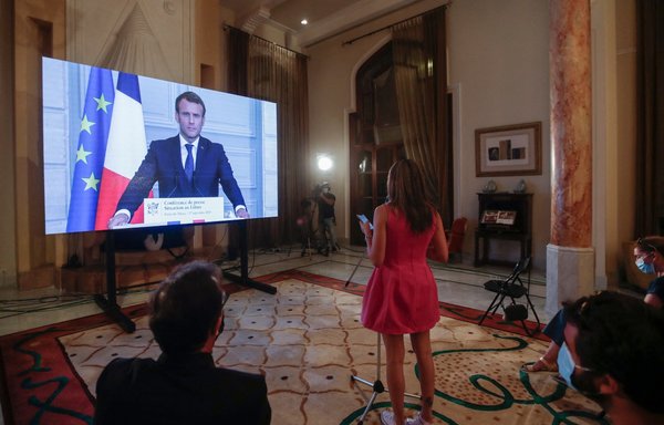 French President Emmanuel Macron listens to a Lebanese journalist's questions during a virtual press conference broadcast at the French ambassador's residence in Beirut on September 27. [Anwar Amro/AFP]