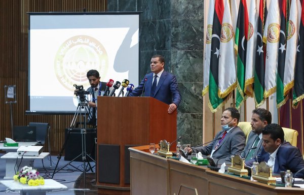 رئيس الوزراء الليبي المكلف عبد الحميد دبيبة يلقي كلمة أمام النواب خلال الجلسة البرلمانية الأولى التي التئمت في 9 آذار/مارس. وقال فيها إن على المرتزقة الأجانب ʼمغادرةʻ ليبيا. [محمود تركيا/وكالة الصحافة الفرنسية]