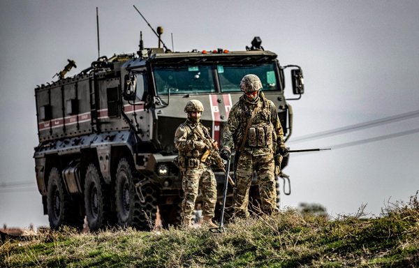 A Russian soldier sweeps for objects with a metal detector during a joint Russian-Turkish military patrol in the countryside near Darbasiyah along the border with Turkey in Syria's northeastern al-Hasakeh province on November 30, 2020. [Delil Souleiman/AFP]