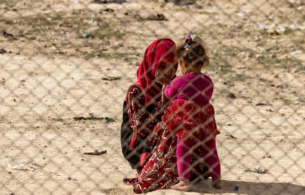 A young girl interacts with a toddler at al-Hol camp, which holds suspected relatives of ISIS members, in north-eastern Syria's al-Hasakeh province on March 3. [Delil Souleiman/AFP]