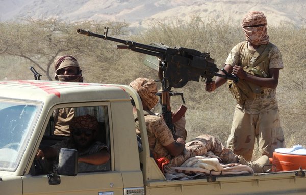 Pro-government fighters in Yemen ride in the back of a pickup truck with mounted heavy machine gun while closing in on a suspected location of an AQAP leader during an offensive in Hadramaut province's Mesini Valley on February 21, 2018. [Saleh al-Obeidi/AFP]