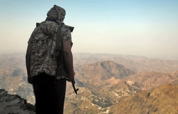 A fighter loyal to the Yemeni government keeps watch over a valley west of Taez on March 8, 2021. [AHMAD AL-BASHA / AFP]