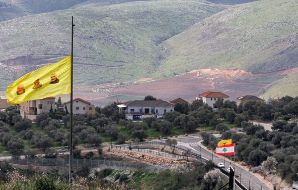 A photo taken February 15 shows a Hizbullah banner of the faces of slain deputy leader of Iraq's Popular Mobilisation Forces Abu Mahdi al-Muhandis, Hizbullah military leader Imad Moghniyeh, and top Iranian general Qassem Soleimani flying in Lebanon's southern plain of Marjayoun. [Mahmoud Zayyat/AFP]
