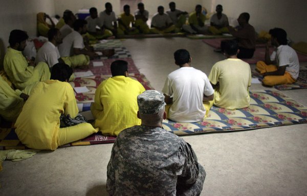 A US soldier listens in on an Islamic discussion course for detainees inside the Camp Bucca detention in Iraq in 2008. [AFP PHOTO/DAVID FURSTDAVID FURST / AFP]