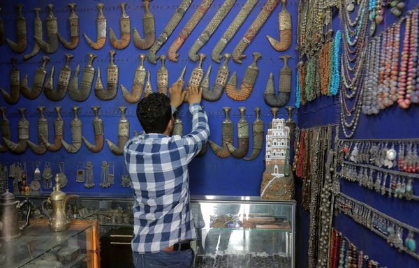 A vendor arranges traditional daggers known as Janbiya and other items for sale on July, 14, 2020 in Yemen's third city of Taez. [Ahmad al-Basha/AFP]