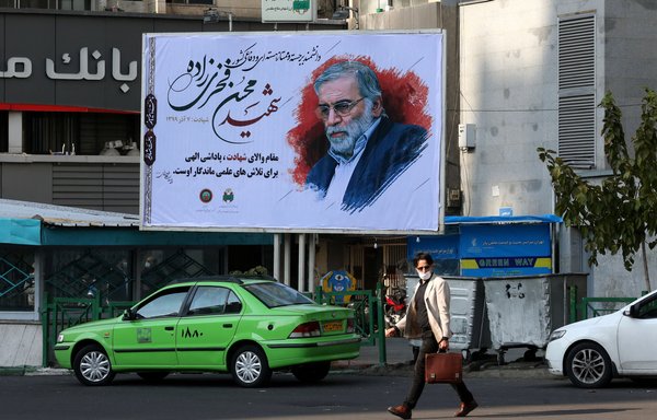 An Iranian man walks by a billboard of slain Iranian nuclear scientist Mohsen Fakhrizadeh in Tehran, on November 30, 2020. Fakhrizadeh's killing further exposed the regime's vulnerable security. [Atta Kenare/AFP]