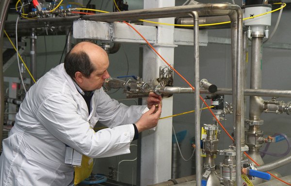 An unidentified International Atomic Energy Agency (IAEA) inspector disconnects the connections between the twin cascades for 20% uranium production at the nuclear research centre of Natanz in 2014. [Kazem Ghane/IRNA/AFP]
