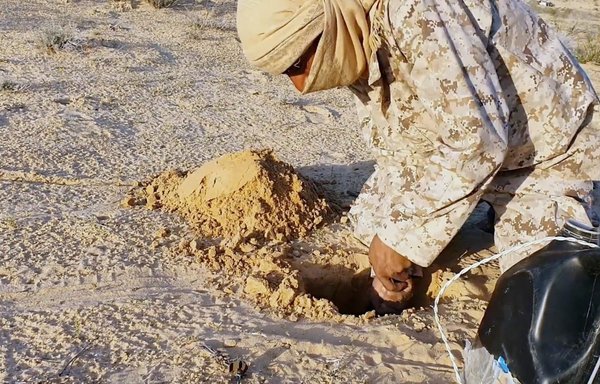 مسلح تابع لداعش يظهر وهو يزرع عبوة ناسفة في سيناء في لقطة من شريط فيديو نشر على تطبيق تليغرام يوم 17 نيسان/أبريل.