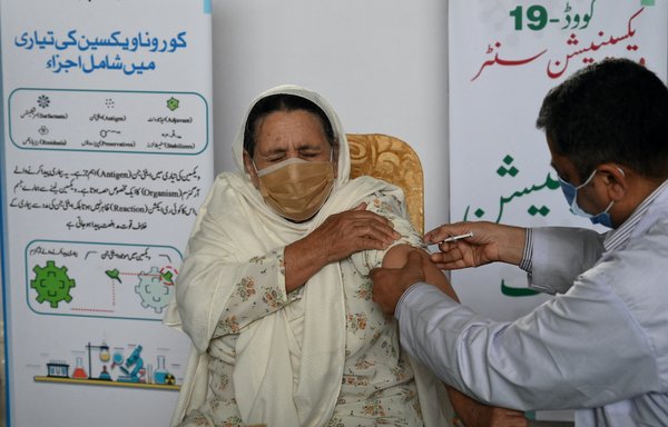 An elderly woman receives a dose of Chinese-made Sinopharm vaccine in Lahore on March 16. [Arif Ali/AFP]