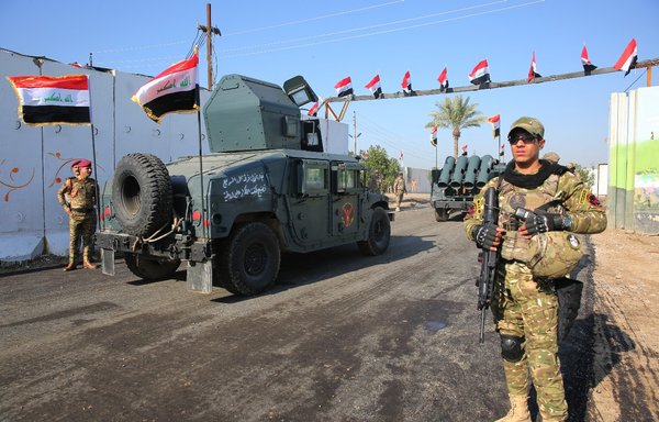 Members of Iraq's Rapid Response forces stand near armoured vehicles during a December 10, 2018 ceremony at a military base inside Baghdad's International Airport. [Ahmad al-Rubaye/AFP]