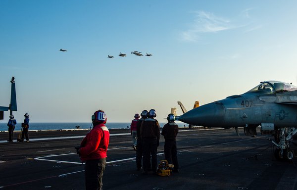 US Navy F/A-18F and F/A-18E Super Hornet fighter jets, an E-2C Hawkeye tactical airborne early warning aircraft and French Marine Nationale Dassault Rafale fighter jets fly in formation over the aircraft carrier USS Dwight D. Eisenhower, during dual carrier operations with the aircraft carrier Charles de Gaulle in the Arabian Sea on April 13. [US Navy]