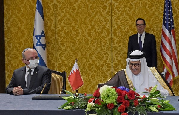 Israel's National Security Advisor Meir Ben Shabbat and Bahraini Foreign Minister Abdullatif bin Rashid al-Zayani sign a normalisation agreement in the Bahraini capital Manama on October 18, officially establishing relations, as then-US Treasury Secretary Steve Mnuchin looks on. [Mazen Mahdi/AFP]