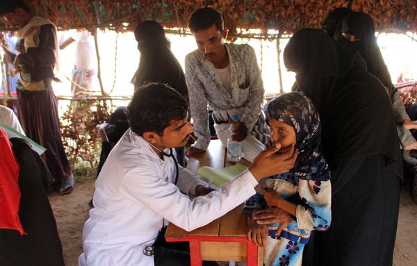 A doctor checks a displaced Yemeni girl at a mobile clinic set up by a local medical organisation at al-Mangoura camp for internally displaced persons in Bani Hasan, in the northern Hajjah province, on April 7, 2018. [Essa Ahmed/AFP]