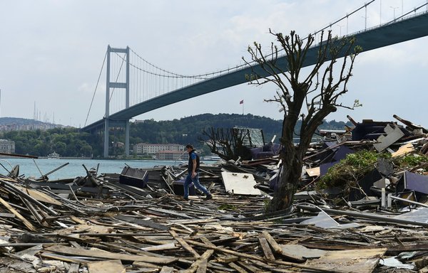 A man walks through debris from the the Reina nightclub near Bosphorus bridge in Istanbul on May 22, 2017, after it was demolished by Istanbul authorities. The nightclub was targeted by a New Year's Eve attack, later claimed by ISIS, that left 39 dead. [Yasin Akgul/AFP]