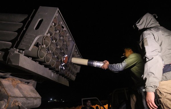 Members of Iran-backed Iraqi militias load rockets into a multiple rocket launcher in this file photo from 2018. [Ahmad al-Rubaye/AFP]