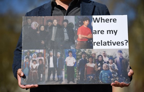 أحد أبناء أقلية الأويغور يحمل لافتة خلال تظاهرة نظمت بلندن في 22 نيسان/أبريل، لمطالبة البرلمان البريطاني بالاعتراف باضطهاد الصين للمسلمين على أنه إبادة جماعية وجرائم ضد الإنسانية. [جاستن تاليس/وكالة الصحافة الفرنسية]