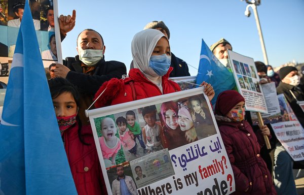 أبناء من أقلية الإيغور يتظاهرون في اسطنبول بالقرب من القنصلية الصينية يوم 22 شباط/فبراير الماضي وهم يحملون لافتات تطالب بالكشف عن مصير أقاربهم المسجونين في "معسكرات إعادة التثقيف". [أوزان كوسي/وكالة الصحافة الفرنسية]