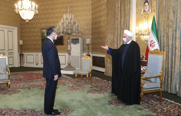 Chinese Foreign Minister Wang Yi visits Iranian President Hassan Rouhani in Tehran March 27. Iranian social media users and civil society activists harshly criticised the regime for 'selling Iran' in a deal whose details are murky at best. [Iranian presidential office]