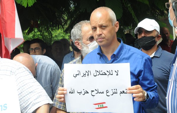 Protesters call for the full implementation of United Nations Security Council Resolution 1559, which calls for the disbanding and disarmament of all militias in Lebanon, and decry Iran's interference in their country outside the French embassy in Beirut on July 14. [Ziad Hatem/Al-Mashareq]