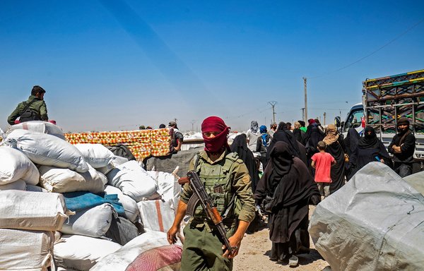 A member of Kurdish security forces watches preparations as another group of Syrian families is released from the Kurdish-run al-Hol camp, which holds relatives of suspected 'Islamic State of Iraq and Syria' (ISIS) fighters, in the northeastern Syrian al-Hasakeh province, on May 11. [Delil Souleiman/AFP]
