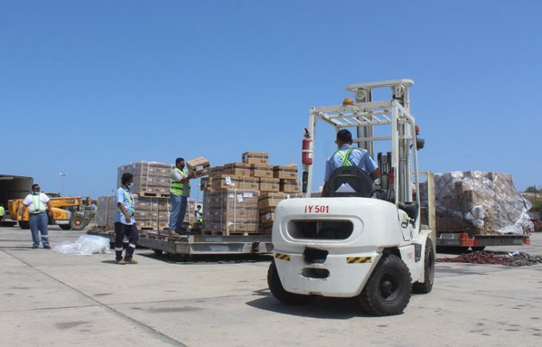 Employees transport boxes containing vials of the AstraZeneca/COVISHIELD vaccine against the coronavirus, upon the arrival of the first shipment at Aden's airport on March 31. [Saleh Obaidi/AFP]