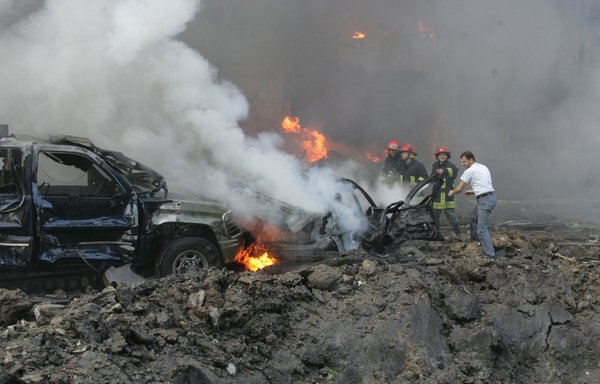 In this file photo taken February 14, 2005, firemen try to extinguish the blaze engulfing one of the cars of the convoy of former Lebanese prime minister Rafik al-Hariri at the scene of a massive explosion in Beirut. The Special Tribunal for Lebanon, which tries suspects over the bombing, risks closure over severe funding shortfalls. [Joseph Barrak/AFP]