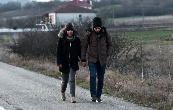 Migrants from Iran walk along the Greek-Turkish border in the village of Sofiko, Greece, on March 2, 2020. [Sakis Mitrolidis/AFP]