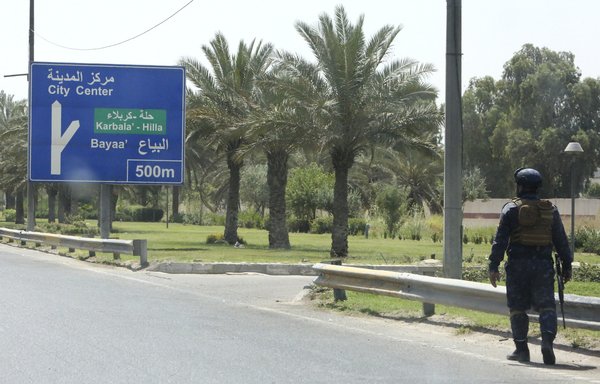 A photo taken on June 10 shows a member of the Iraqi security forces standing guard on a main road outside Baghdad International Airport, one day after a booby-trapped drone, a signature method used by pro-Iran forces, struck the airport area. [Sabah Arar/AFP]