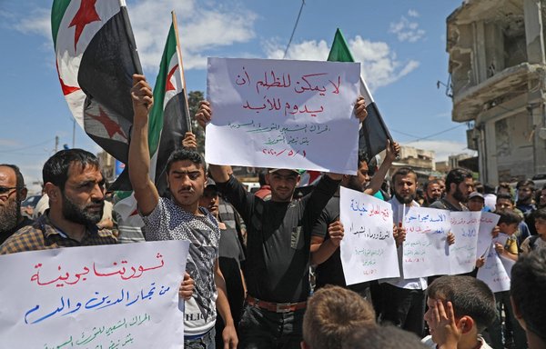 Syrian demonstrators rally in the Idlib province town of Binnish on May 1, 2020, to protest against a reported attack by Tahrir al-Sham, carried out on a protest the previous day. [Omar Haj Kadour/AFP]