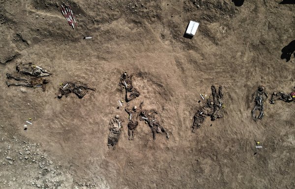 این عکس هوایی که روز ۲۳ خرداد گرفته شده، ظاهراً بقایای انسان هایی را نشان می دهد که گفته می شود قربانیان قتل عام زندان بادوش توسط داعش در سال ۱۳۹۳ هستند. این بقایای اجساد از یک گور جمعی در روستای بادوش، واقع در شمال غربی موصل در شمال عراق، بیرون آورده شده اند. [زیاد العبیدی/خبرگزاری فرانسه]