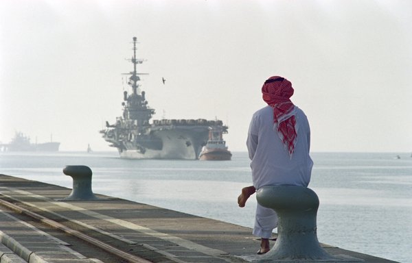 A Saudi man looks at the French aircraft carrier Clemenceau arriving at the port of Yanbu, in this file photo from September 24, 1990. [Pascal Guyot/AFP]