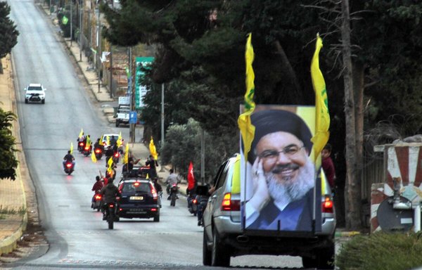 أنصار حزب الله بموكب في كفركلا يوم 25 تشرين الأول/أكتوبر 2019، وهم يحملون صورا لحسن نصر الله. ويطالب عدد متزايد من الدول الأمم المتحدة بتصنيف حزب الله كمنظمة إرهابية. [علي ضياء/وكالة الصحافة الفرنسية]
