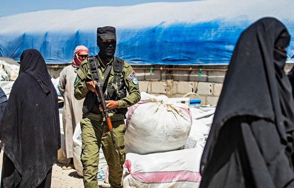 A member of Kurdish security stands guard amid preparations for departure from al-Hol camp in Syria on May 11. Sanctions implemented in May targeted efforts to transfer money from foreign donors to ISIS operatives inside the camp. [Delil Souleiman/AFP]
